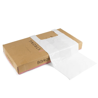 Zoom bild av Vit plastbärkasse 31 liter med hängselhandtag delvis utdragen ur brun dispenserkartong märkt Strong och Bärkas
