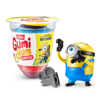 Zoom bild av Zuru Gumi Yum Surprise Minions förpackning 26g med färgglada gummigodisbitar och en Bob Minion-figur med tillbehör bredvid